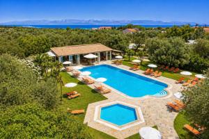 an aerial view of a pool with chairs and umbrellas at Kosmas Apartments in Roda