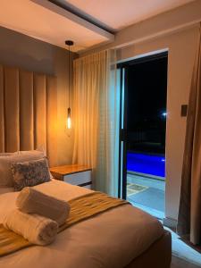 a bedroom with a bed with a view of a balcony at Maison De luxe in Thohoyandou