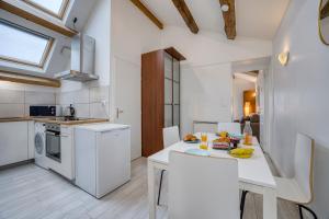 a kitchen with white appliances and a table with chairs at COLIVING - bedroom Salon & TV in Saint-Jean-de-Gonville