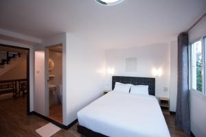 a bedroom with a white bed and a dining room at Hoppers Place Donmuang in Bangkok
