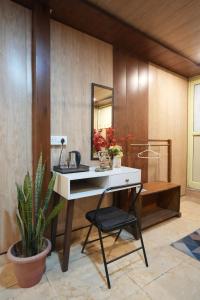ein Badezimmer mit Schreibtisch, Spiegel und Pflanze in der Unterkunft Full Stop Hostel in Rishikesh