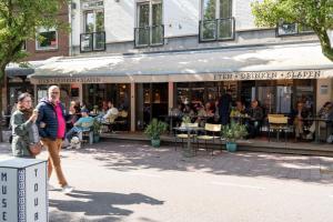 a group of people walking in front of a restaurant at Juuls Domburg in Domburg