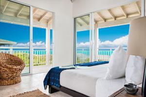 Schlafzimmer mit einem Bett und Meerblick in der Unterkunft Sailrock South Caicos - Island Hop Flight Included in South Caicos