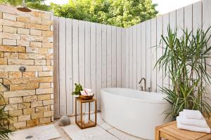 uma casa de banho com uma banheira e uma cerca de madeira em Sailrock South Caicos - Island Hop Flight Included em South Caicos