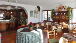 una sala da pranzo con tavoli e un albero di Natale di Hotel Piccolo Mondo a Bormio