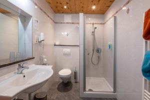 ein Badezimmer mit Dusche, Waschbecken und Toilette in der Unterkunft Hotel Chavalatsch in Taufers im Münstertal