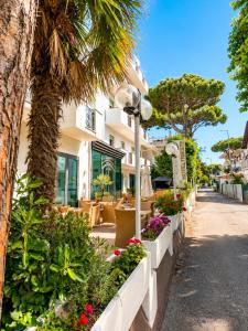 a street with flowers and plants in front of a building at HOTEL TRIESTE in Riccione