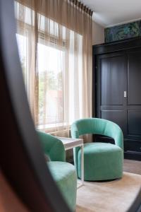 a living room with two chairs and a table and a window at Juuls Domburg in Domburg +20 photos