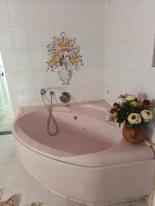 a pink bath tub with flowers in a bathroom at L'Antica Dimora Toscana in Cecina