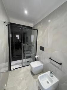 a white bathroom with a sink and a shower at Xenia Room in Gela +23 photos