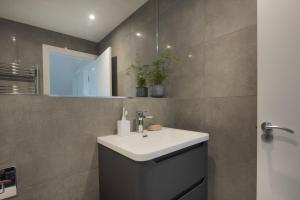 a bathroom with a white sink and a mirror at Fairsky - Sea Views and Allocated Parking in Carbis Bay +32 photos