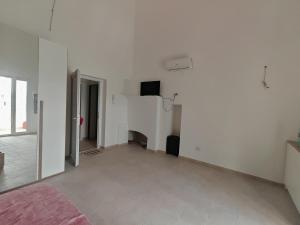 an empty room with white walls and a fireplace at Alighieri Rooms in Triggiano