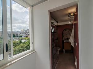 a hallway with a window and a view of a city at Alighieri Rooms in Triggiano