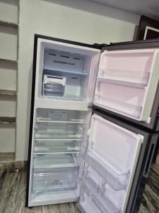 an empty refrigerator with its door open in a room at Velankanni Home Stay in Mangalore