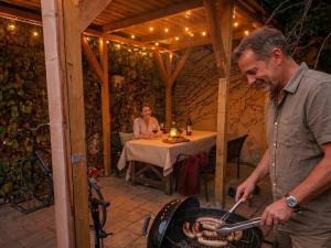 a man is cooking food on a grill in a patio at Weinschlafwagen Bautzen in Bautzen