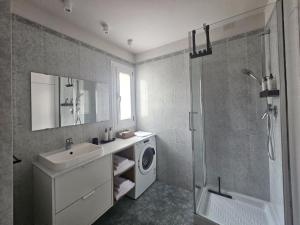 a bathroom with a sink and a washing machine at LuMI Apartment - Nel cuore del parco di Milano 3, vicino Humanitas in Basiglio +4 photos