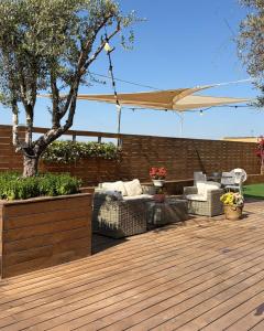 a wooden deck with chairs and an umbrella at סוויטת בית ינאי in Beit-Herut +12 photos