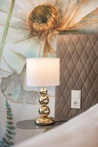 a lamp on a table in a bedroom with a painting at CIRCLE Boutique Hotel Melk in Melk