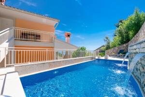 a swimming pool with a waterfall and a house at Villa Pia by Briskva in Brseč