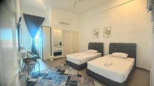a bedroom with two beds and a mirror at Hotel O HNR INN in Kuala Terengganu