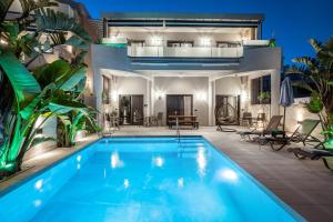 a villa with a swimming pool and a house at Old Cinema Suites - Stylishly Decorated Retreat with Pool or Jacuzzi by the Sea in the Heart of Laganas Βy Villa Mana Gers in Laganas