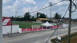 a tennis court with a white tent on a field at Hotel O HNR INN in Kuala Terengganu