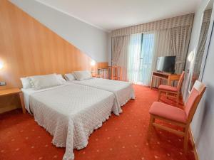 a bedroom with a white bed and a television at Hotel Mirador de Gornazo in Gormazo +14 photos