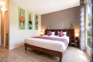 a bedroom with a large bed in a room at Logis Latitude Ouest Hôtel Restaurant & Spa in Locronan +63 photos