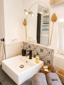a bathroom with a white sink and a mirror at Côte d'Opale - Maison Cocooning Classé 3 Étoiles in Marquise +46 photos