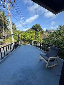 a chair on the balcony of a house at Acqua Rooms & Living in Koh Samui