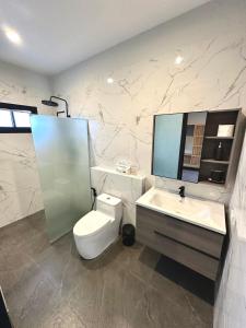 a bathroom with a toilet and a sink and a mirror at Acqua Rooms & Living in Koh Samui
