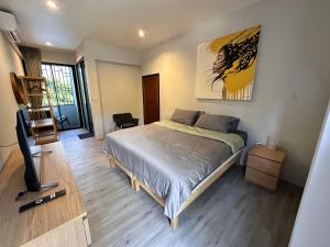a bedroom with a bed and a flat screen tv at Acqua Rooms & Living in Koh Samui