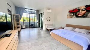a bedroom with a bed and a painting on the wall at Acqua Rooms & Living in Koh Samui +7 photos