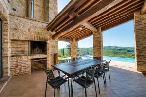 an outdoor patio with a table and chairs and a fireplace at San Venanzo – Casale De' Conti in San Venanzo