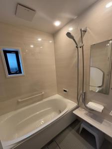 a white bathroom with a tub and a window at LadolcevitA - 総檜サウナ - Private Hinoki Sauna Inn in Mitsugoe
