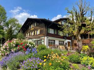 a garden in front of a house with flowers at Gasthof Tenne - Ferie mit Härz in Lenk