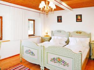 a bedroom with two beds and a chandelier at Farmhouse in Kössen near Kitzbühel Alps in Kössen