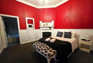a red bedroom with a bed and a fireplace at Whispering Woods Pool Sauna in Maryborough