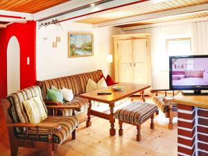 a living room with a couch and a tv at Farmhouse in Kössen near Kitzbühel Alps in Kössen