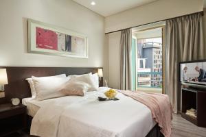 a bedroom with a large bed and a television at Somerset Bencoolen Singapore in Singapore +23 photos