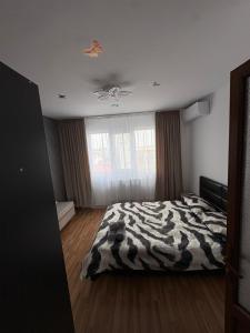 a bedroom with a zebra print bed and a ceiling at Apartament Eric in Mangalia