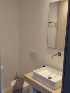 a bathroom with a white sink and a mirror at Aqua villa Studio II in Elafonisos +4 photos