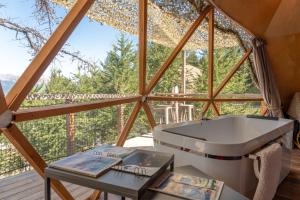 a bathroom in a tree house with a tub at Alpin D'Hôme Hôtel & Spa in Les Orres