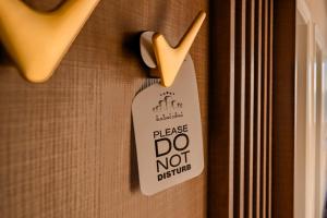 a sign that says please do not disturb hanging on a door at NOYA - Hotel Building Stefan Resort II in Mamaia Sat/Năvodari
