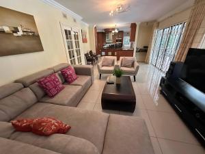 a living room with two couches and a television at Spacious 4BR Home Pool Balconies Krantzkloof in Kloof