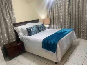 a bedroom with a bed with a blue blanket on it at Spacious 4BR Home Pool Balconies Krantzkloof in Kloof +41 photos
