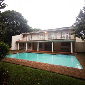 a building with a swimming pool in front of a building at Spacious 4BR Home Pool Balconies Krantzkloof in Kloof
