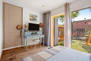 a bedroom with a bed and a desk with a computer at Gite Chez Sophie in Roquebrune-sur-Argens