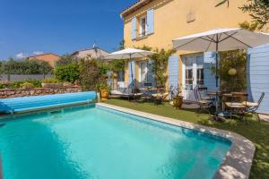 a swimming pool in the yard of a house at Gite Chez Sophie in Roquebrune-sur-Argens