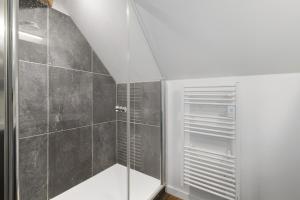 a bathroom with a walk in shower with a glass door at Bulle de Douceur avec Spa in Vallons-de-l'Erdre
